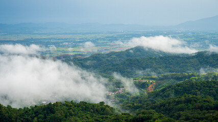 Fototapeta premium Beautiful Mountain landscape foggy windy mountain range green landscape asian farm. Amazing Landscape mountain green field meadow white cloud blue sky on sunrise. Countryside sunlight heaven scenery