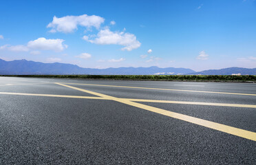 Tranquil Road Leading to Scenic Mountains Under a Clear Blue Sky