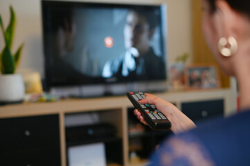 a girl channel surfing with the remote control in her living room