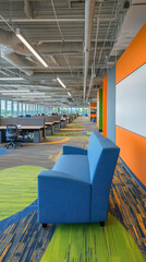 Fototapeta premium Modern office interior with blue couch and colorful carpet in a collaborative workspace.