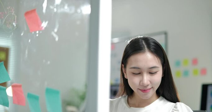 Woman is writing lesson topic strategy on paper sticky notes and paste on the board for learning and preparing on education.