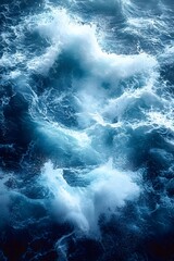 A close-up view of a dramatic ocean wave crashing, creating a spray of white foam against the deep blue water.