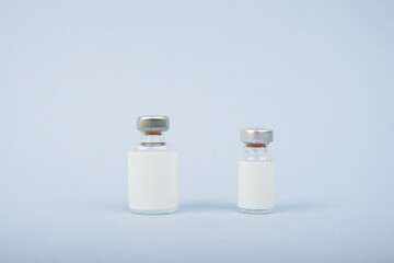 Transparent glass bottles for vaccine injections mockup isolated on blue bright background. Can be use for medicine, cosmetic and other. Ready for your design