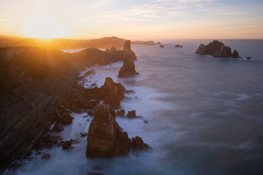 Sunset over ocky coastline at Los Urros De Liencres, Spain