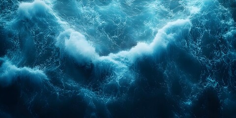 An overhead view of choppy blue water with white foam. The surface of the water is covered in waves and bubbles.