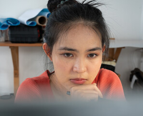 Young beautiful woman sitting at desk working with computer in home office. Asian female architect...