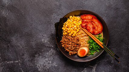 A bowl of ramen with noodles, meat and green onions.