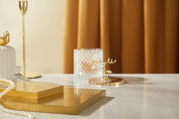 The luxurious image template used for promoting features two gold rectangular platforms with empty space for display products, surrounded by a pearl necklace and other decorations on a white table.