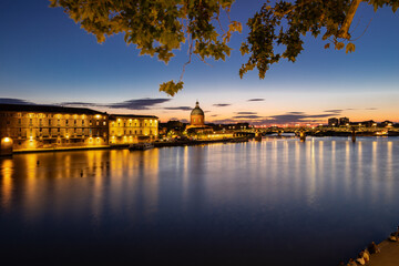 Obraz premium Golden sunset over Garonne river with views on the the pedestrian Saint-Pierre bridge, Place Saint-Pierre and the Grave hospital seen from the riverside 