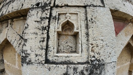 Detailed patterns on a weathered medieval tomb wall, reflecting the artistry and history of ancient burial sites at Jhajjar, Haryana, India 
