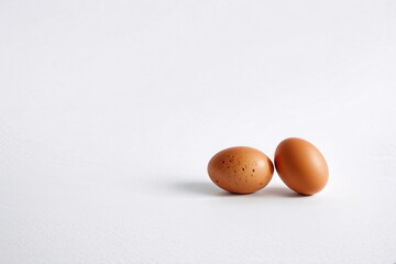 Two brown eggs on a white background