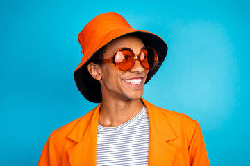 Photo of happy smiling guy wear orange hat look empty space isolated blue color background