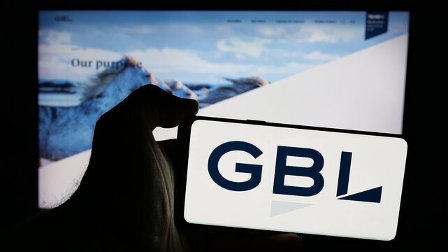 Stuttgart, Germany - 09-29-2024: Person holding mobile phone with logo of company Groupe Bruxelles Lambert S.A. (GBL) on screen in front of web page. Focus on phone display.