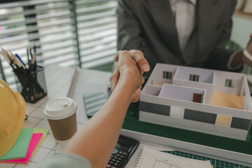 architect and engineer are shaking hand after successfully completing the work, an architect is...