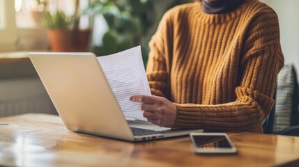 Cozy Work from Home Scene Person in Brown Sweater at Desk with Laptop and Paper Remote Working Concept