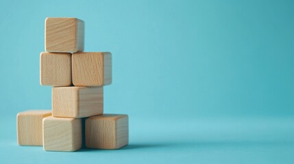 Wooden blocks stacked as steps on a blue paper background, symbolizing upward growth and achievement in business. Lots of copy space for business presentations.
