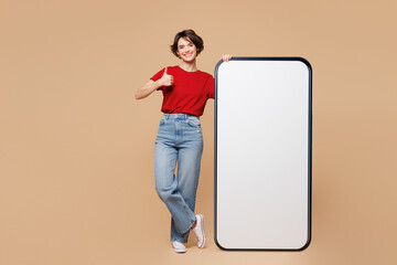 Full body young woman she wear red t-shirt casual clothes big huge blank screen mobile cell phone...