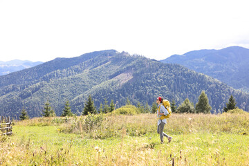 Young woman with backpack hiking in mountains