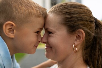 A joyful moment between a mother and her young son outdoors during a sunny day in a park highlighting their loving bond