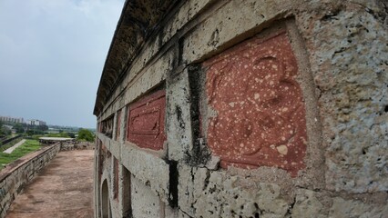 Detailed patterns on a weathered medieval tomb wall, reflecting the artistry and history of ancient...