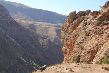 Rocky canyon landscape with steep cliffs and distant valleys.