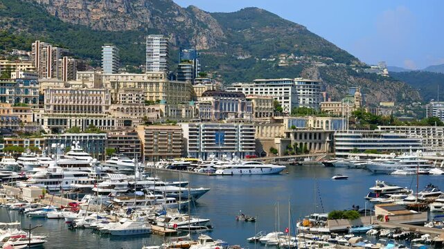 View of boats docked in the Monaco Marina with the skyline of the city on the background