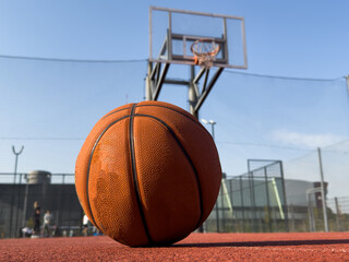 basketball ball on the outdoors court with hoop on the background. Sport equipment