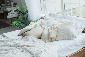 A stylish bedroom featuring a spacious bed with various soft pillows and a soothing blanket