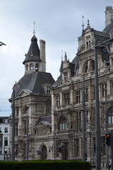 Elegant European historical building with detailed stonework and towers, blending classic architecture with urban elements in a vibrant city atmosphere
