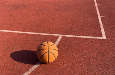 basketball ball on the outdoors court with hoop on the background. Sport equipment