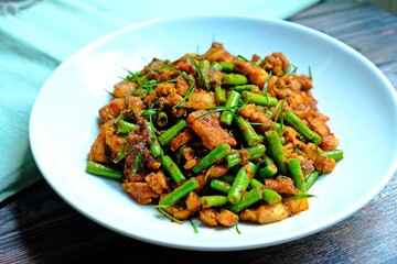 Stir fried crispy pork belly and yard long bean with ginger red curry paste, Authentic Thai food.