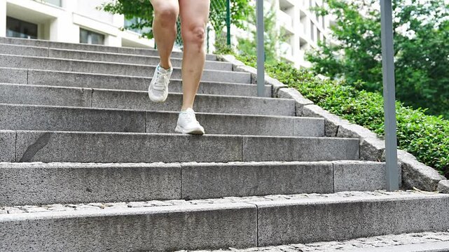 Young woman running up the stairs training workout exercise jogging on steps in city park