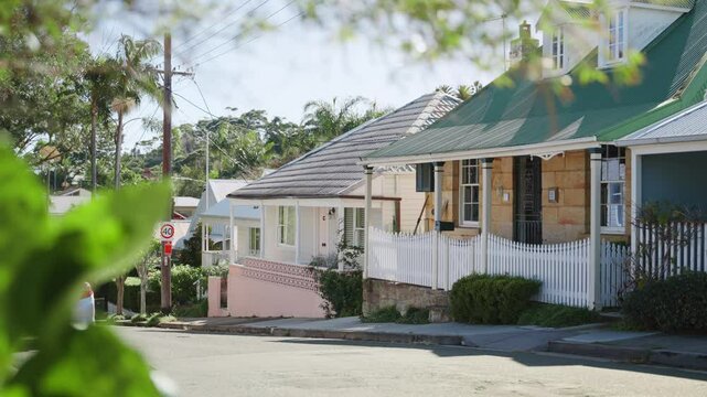 Row of typical simple colorful houses in residential neighborhood in Sydney. Traditional city private houses with front porches in quiet and peaceful street during springtime in sunny Australia