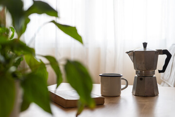 Cozy Morning Scene With Coffee Pot, Mug, And Book On Table