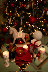Children's toy wooden horse
 Against the background of a Christmas tree with coffee with lights on