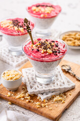 Chia coconut pudding with raspberry smoothie, nuts and cocoa nibs