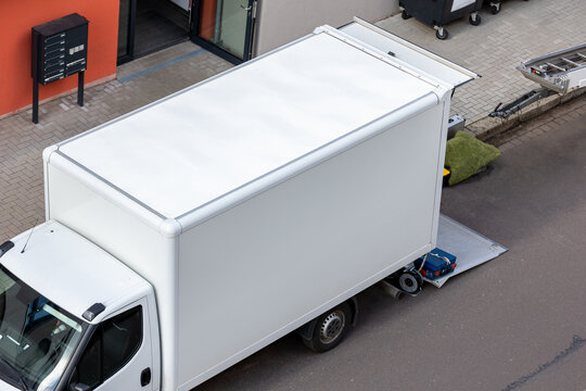 Mover service lifting ladder cargo crane platform vehicle van parked at city street. Retractable furniture elevator machine car pickup truck rental company for relocation and house moving delivery