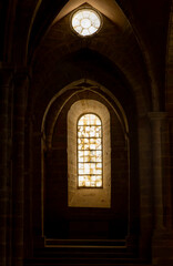 A window in a dark room with a stone archway. Gothic style