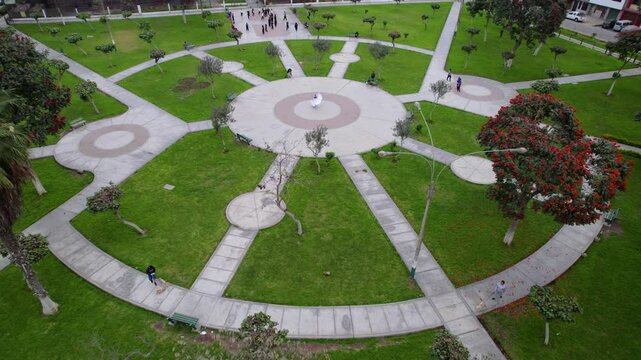 Young girl performing Marinera folk dance at public garden space, Drone shot