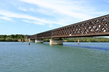 Obraz premium Beautiful Old Iron railway bridge Pont ferroviaire dit viaduc d'Avignon over the sparkling waters of the Rhone River near Avignon, France