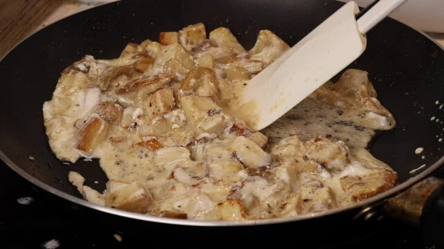 Frying boletus mushrooms in a pan with sauce, baking them to perfection, and stirring with a silicone spatula. Mushroom beef stroganoff recipe