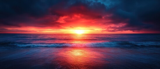 Dramatic sunset over the ocean with waves crashing on the shore.