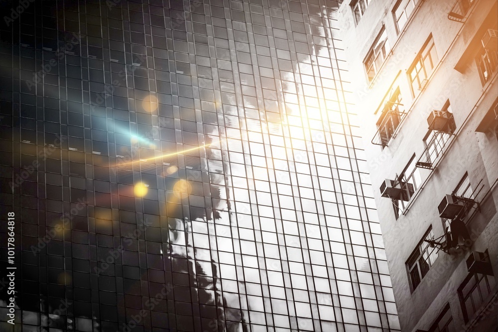 Poster a modern skyscraper in hong kong with a glass facade reflecting sunlight and the sky.