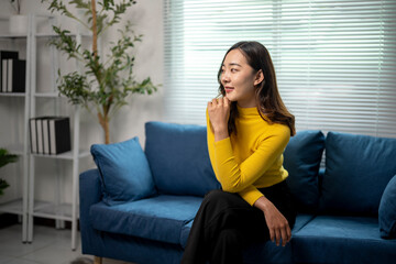 Young professional woman sitting on sofa pondering next steps in modern office