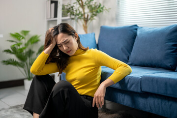 Fototapeta premium Young asian businesswoman suffering from headache at home