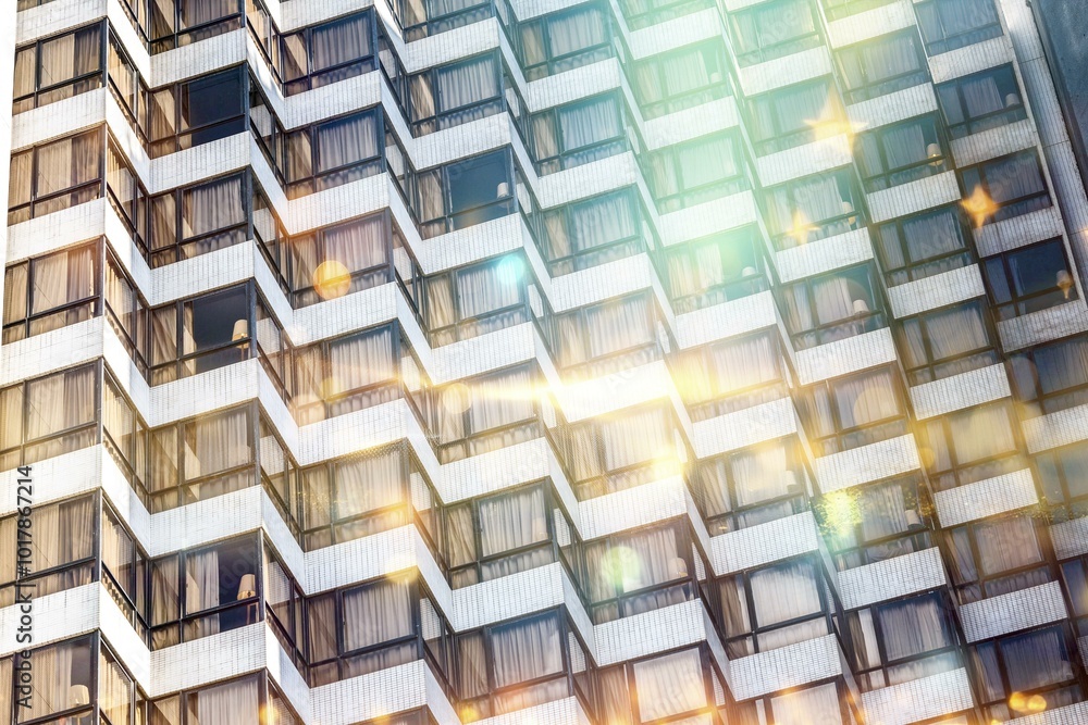 Poster a building with a geometric pattern of windows and tiled walls, illuminated by sun glare.