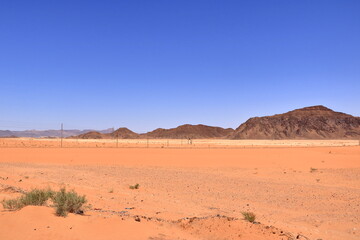 Old train rails almost completely covered with desert sand in Wadi Rum, Jordan