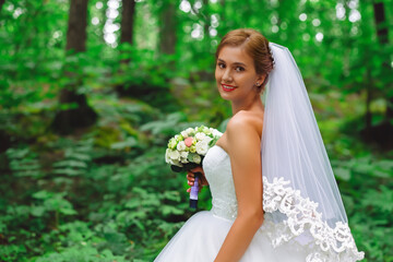 Girl white dress at wedding the forest. female bride w concept. girl in white and green dress standing in a forest at a wedding. a girl in white and green is standing in a forest wedding for her.