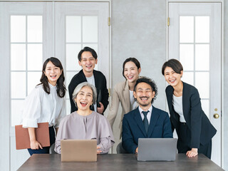 Fototapeta premium オフィスで笑う幅広い世代のビジネスパーソンのチーム