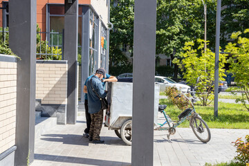 A man is standing next to a cart with a bicycle on it